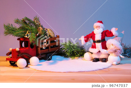Christmas pedestal for the product, still life composition, with a New Year's car, with a Christmas tree in the back, Santa Claus meets the new year with a snowman, mockup. High quality photo Christmas pedestal for the product, still life composition, with a New Year's car, with a Christmas tree in the back, Santa Claus meets the new year with a snowman, mockup. High quality photo 96747037