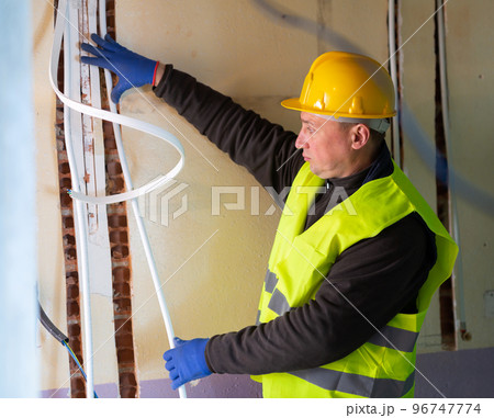 Electrician lying down cable duct during repair works 96747774