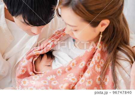 赤ちゃんに授乳をする母親とお父さん 赤ちゃんに授乳をする母親とお父さん 96747840