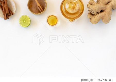 Top view of a cup of tea with ginger root, lime, cinnamon and teapot on white background. Health drink concept.. Top view of a cup of tea with ginger root, lime, cinnamon and teapot on white background. Health drink concept.. 96748181