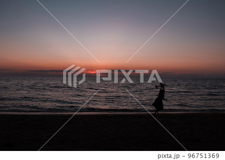 happy girl running with a kite at sunset outdoors. A child runs with a kite at sunset against the backdrop of the sea. Family vacation. High quality photo. happy girl running with a kite at sunset outdoors. A child runs with a kite at sunset against the backdrop of the sea. Family vacation. High quality photo. 96751369