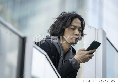スマートフォンの画面を見る若い男性 スマートフォンの画面を見る若い男性 96752105