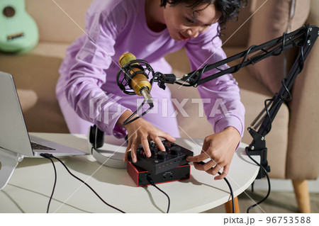 Teenage girl setting equipment for recording podcast at home 96753588