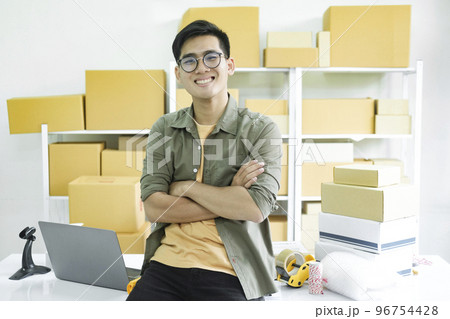 Young male online business owner working and looking at camera. 96754428