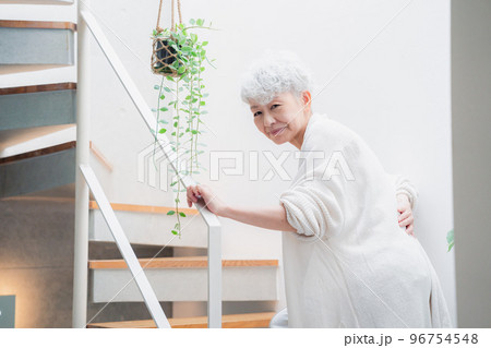 階段で腰痛に苦しむ高齢の女性 96754548
