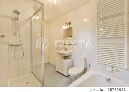 Modern home interior design of white bathroom with open bathtub and shower separated from toilet by partition wall Modern home interior design of white bathroom with open bathtub and shower separated from toilet by partition wall 96755041