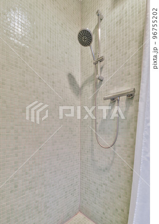 Wall hung toilet and small sink in corner in lavatory room with beige tile 96755202