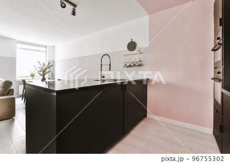 Simple interior of light living room with gray sofa in front of TV and dining table against window Simple interior of light living room with gray sofa in front of TV and dining table against window 96755302