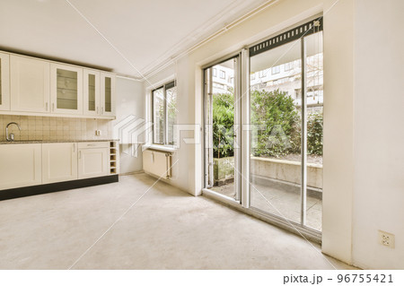 Interior of empty white kitchen with windows and wooden parquet floor Interior of empty white kitchen with windows and wooden parquet floor 96755421