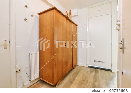Light narrow hallway with many doors in white walls and glowing lamp over lumber floor Light narrow hallway with many doors in white walls and glowing lamp over lumber floor 96755668