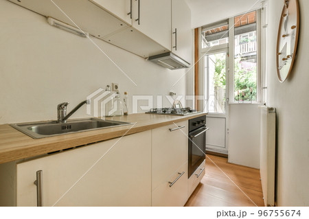 Interior of light kitchen room with balcony doors in contemporary apartment at daytime 96755674