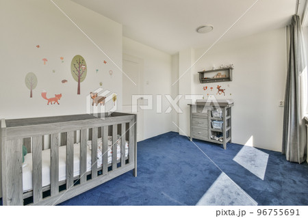 Interior of white room with baby gray crib and near window with grey chest of drawers in daylight Interior of white room with baby gray crib and near window with grey chest of drawers in daylight 96755691
