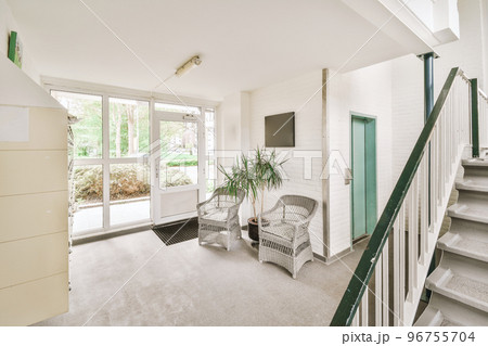 White hallway with wooden stairway leading to second floor of modern luxury apartment with minimalist interior design White hallway with wooden stairway leading to second floor of modern luxury apartment with minimalist interior design 96755704