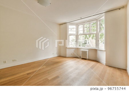 Interior of empty white room with windows with parquet and radiator Interior of empty white room with windows with parquet and radiator 96755744