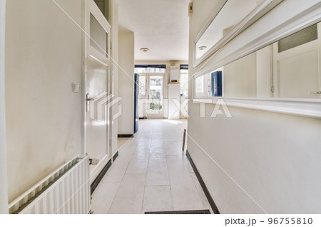 Interior of modern flat in minimal style with narrow empty corridor illuminated by lamps Interior of modern flat in minimal style with narrow empty corridor illuminated by lamps 96755810