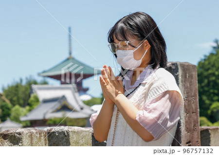 マスクを着けてお参りをする若い女性 マスクを着けてお参りをする若い女性 96757132