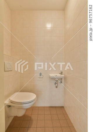 Stylish bathroom interior design with white toilet and bathtub with shower in modern apartment 96757162