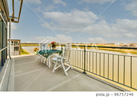 Sitting area in balcony with comfortable furniture around beautiful view 96757246