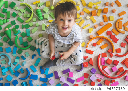 Wooden bricks Montessori material rainbow spectrum. Little cute boy plays with cubes. 96757520