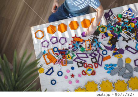 Top view cute baby male kid hands assembling details learning geometric pattern constructor closeup 96757827