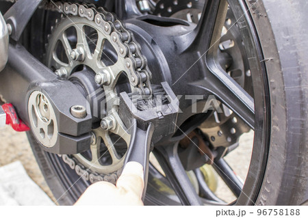 コの字型の専用ブラシでバイクのチェーンを清掃する コの字型の専用ブラシでバイクのチェーンを清掃する 96758188