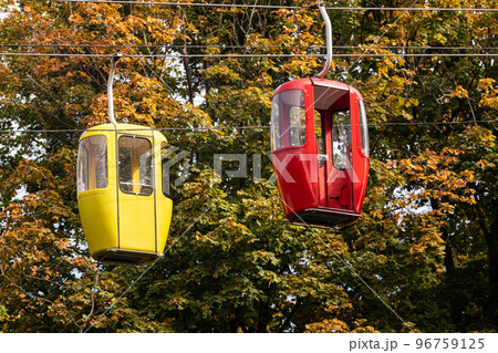 Red and yellow cable car cabins in autumn forest 96759125
