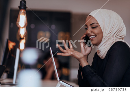 Young African American businesswoman talking on a smartphone in a modern startup office. Marketing concept. Multi-ethnic society. 96759733