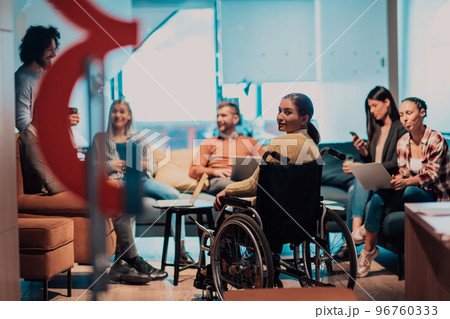 Businesswoman in wheelchair having business meeting with team at modern office. A group of young freelancers agree on new online business projects Businesswoman in wheelchair having business meeting with team at modern office. A group of young freelancers agree on new online business projects 96760333