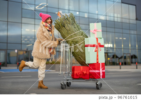Woman buys Christmas tree and presents at mall 96761015