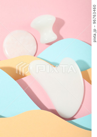 Face care concept with gua sha on multicolor background 96763460