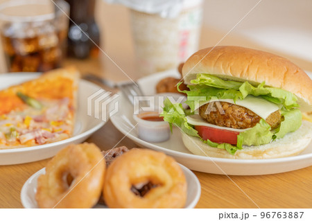 テーブルの上のハンバーガー　ピザ　ドーナツ　カップ麺　コーラ 96763887