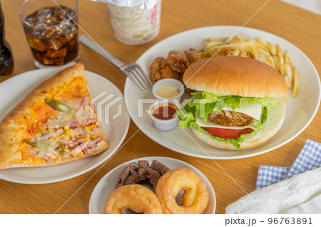 テーブルの上のハンバーガー　ピザ　ドーナツ　カップ麺　コーラ 96763891