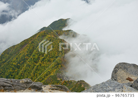 甲斐駒ヶ岳山頂付近から望む六方石、駒津峰の稜線へ迫り来る雲海 96765735
