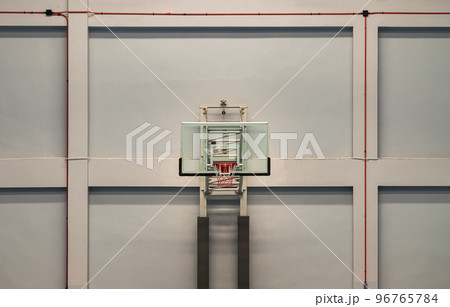 View of Basketball fiberglass backboard, Hoop orange metal ring and white orange net with cement wall background. View of Basketball fiberglass backboard, Hoop orange metal ring and white orange net with cement wall background. 96765784