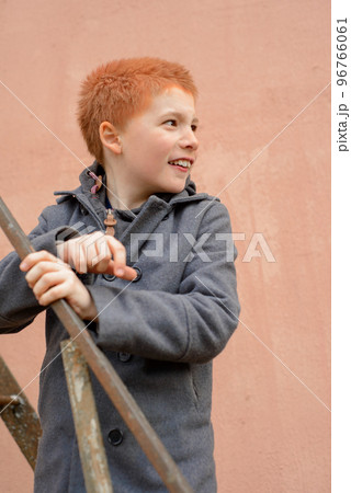 red-haired boy in a grey coat climbed the rusty metal ladder to red-haired boy in a grey coat climbed the rusty metal ladder to 96766061