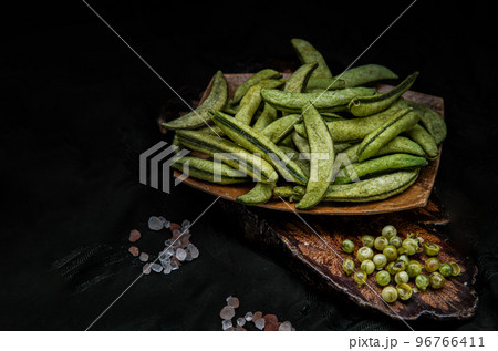 Healthy roasted sugar snap peas on dark wooden background. Home cooking, Dark tone, Space for text, Selective Focus. Healthy roasted sugar snap peas on dark wooden background. Home cooking, Dark tone, Space for text, Selective Focus. 96766411