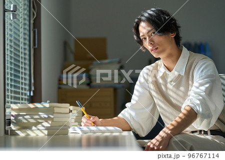 窓辺で勉強をする若い男性 窓辺で勉強をする若い男性 96767114