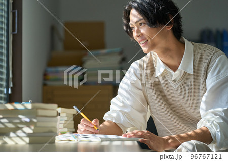 窓辺で勉強をする若い男性 96767121