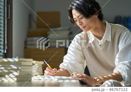 窓辺で勉強をする若い男性 96767122