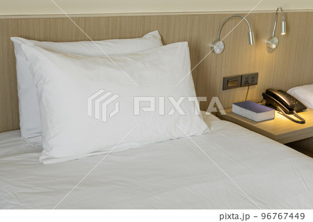 Modern bedroom interior with white pillow and bedside tables Modern bedroom interior with white pillow and bedside tables 96767449