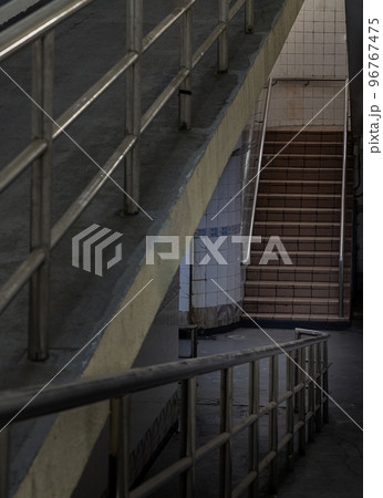 Stairs leading to interior view of public underpass with white tiled walls and CCTV. Stairs leading to interior view of public underpass with white tiled walls and CCTV. 96767475