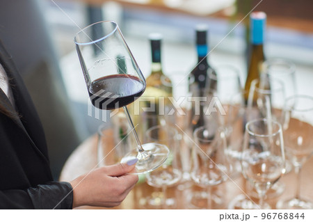 woman's hand with a glass of red wine. woman's hand with a glass of red wine. 96768844