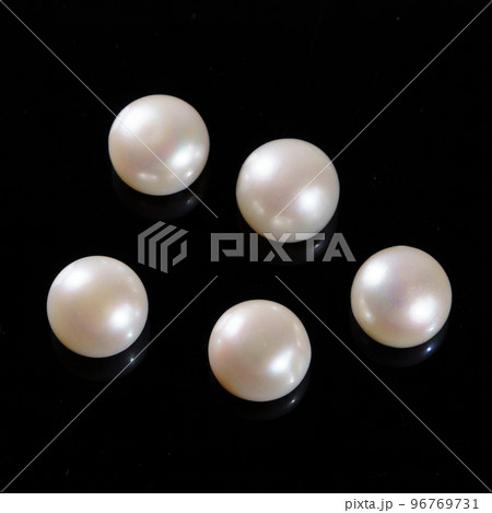 Natural pearls on a black background. White, yellowish round pearls Natural pearls on a black background. White, yellowish round pearls 96769731