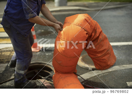 Sewer repair. Pumping waste from hatch. Open hatch. Worker controls air supply. 96769802