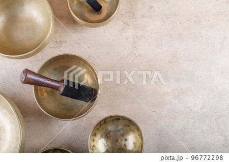 Tibetan singing bowls with sticks used during mantra meditations on beige stone background, top view, copy space Tibetan singing bowls with sticks used during mantra meditations on beige stone background, top view, copy space 96772298
