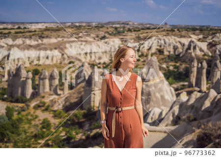 Young woman exploring valley with rock formations and fairy caves near Goreme in Cappadocia Turkey 96773362