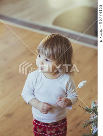 Adorable baby playing with magic wand near christmas tree Adorable baby playing with magic wand near christmas tree 96774158