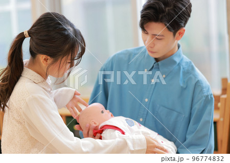 赤ちゃんの抱っこの方法を学ぶ男性と教えている講師_1 赤ちゃんの抱っこの方法を学ぶ男性と教えている講師_1 96774832