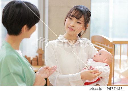 赤ちゃんの抱っこの方法を学ぶ女性と教えている講師_2 赤ちゃんの抱っこの方法を学ぶ女性と教えている講師_2 96774874