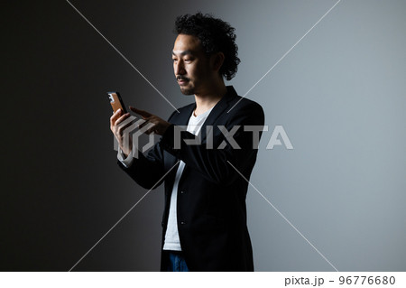 スマホを持つ髭の男性 96776680